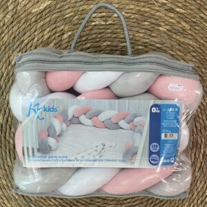Protector para cuna , en forma de trenza ,combinada rosa gris y blanca.